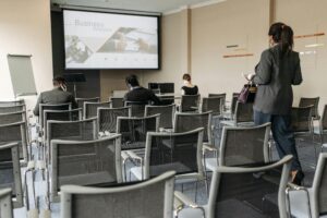 Conference room setup for a business seminar, with attendees wearing masks.